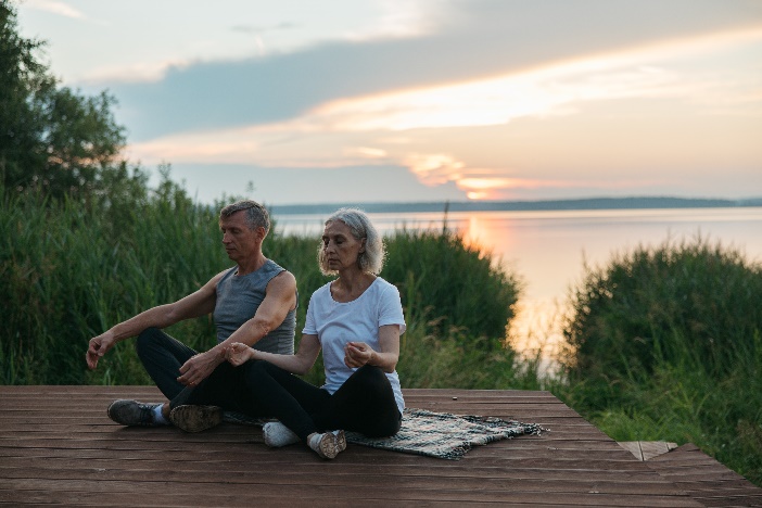 Elderly couple doing yoga and meditation